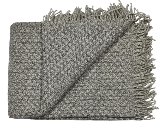 Et foldet, gråt, vævet tæppe med struktureret mønster og frynsede kanter.