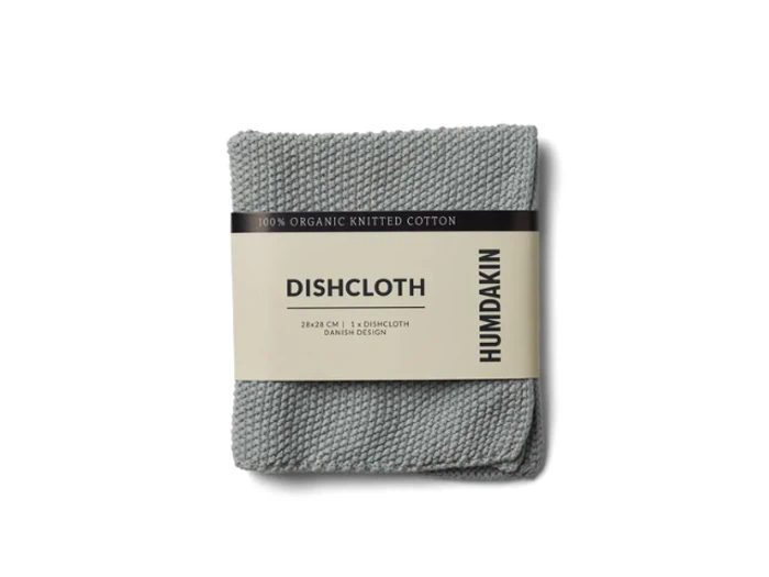 En foldet grå strikket bomuldskarklud med en etiket med teksten DISHCLOTH og HUMDAKIN på hvid baggrund.