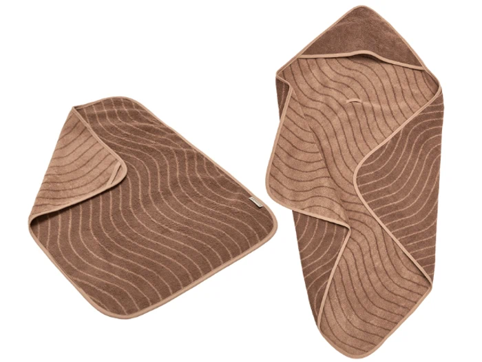 To brune håndklæder med bølgelinjemønstre, det ene foldet til en trekant og det andet delvist rullet, vist på en hvid baggrund.