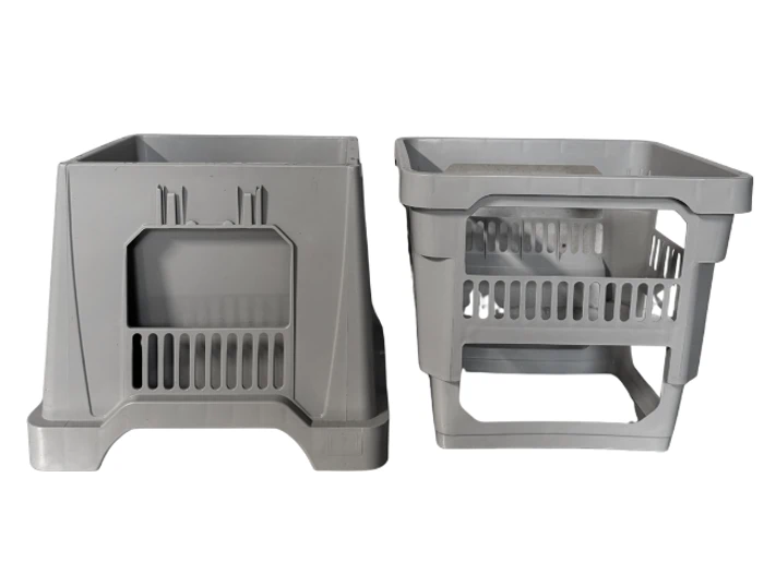 To stabelbare grå plastkasser med åbne sider og ventilationsåbninger, placeret side om side på en hvid baggrund.