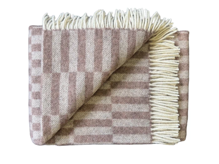 Et foldet uldtæppe med et beige og lysebrunt ternet mønster med cremefarvede frynser langs den ene kant.