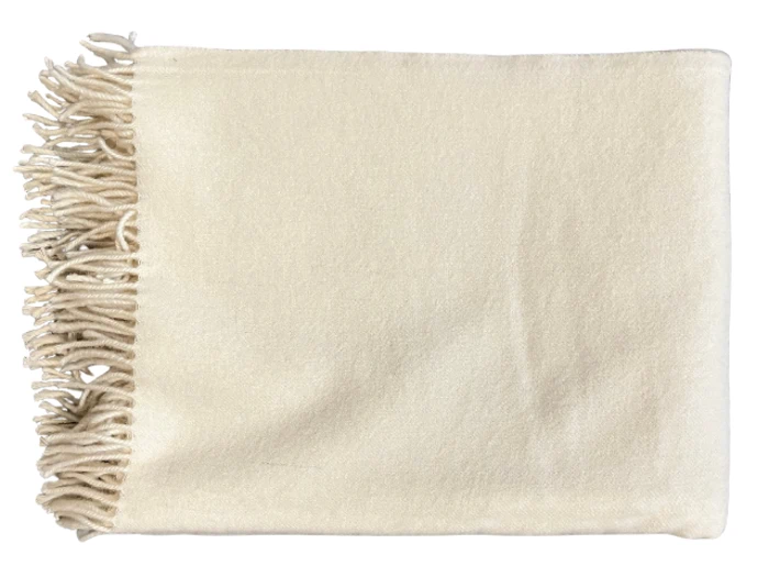 Et pænt foldet cremefarvet tæppe med frynsede kanter på den ene side, vist på en hvid baggrund.