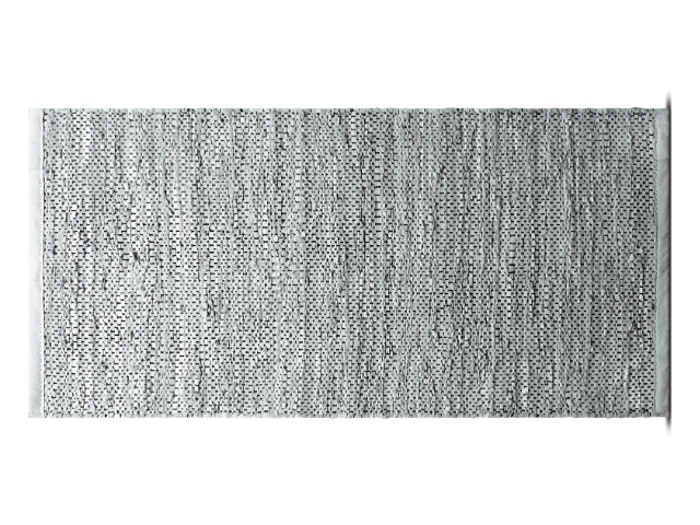 Et rektangulært, struktureret, vævet gråt tæppe med et spættet sort og hvidt mønster på en hvid baggrund.