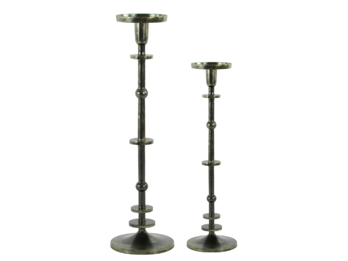 To metalliske lysestager i forskellige højder, begge med runde baser og dekorative cirkulære accenter langs stilkene, står side om side mod en hvid baggrund.