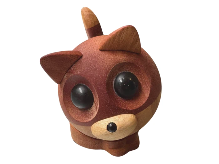 En lille, rund rævefigur af træ med store sorte øjne, opretstående ører, en spids snude og en kort hale, vist på en hvid baggrund.