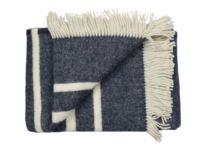 Et foldet, mørkeblåt og hvidt uldtæppe med frynsede kanter og et stribet mønster.