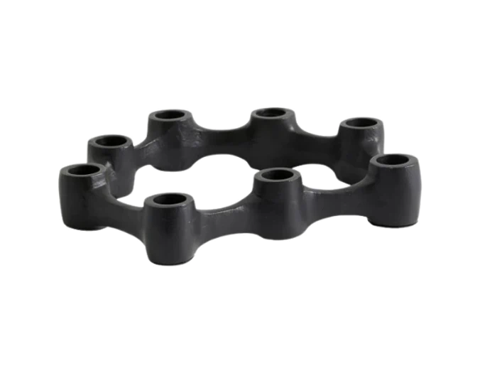 En sort, cirkulær gummikobling med seks huller og hævede forbindelsespunkter, placeret på en hvid baggrund.