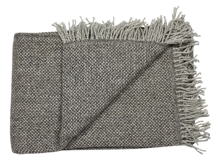 Et foldet, vævet gråt tæppe med frynsede kanter vises på en hvid baggrund.