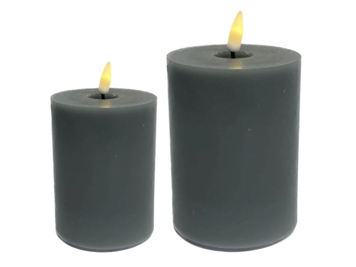 To grå bloklys, et kortere og et højere, begge med tændte flammer mod en hvid baggrund.