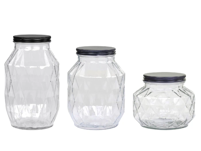 Tre tomme, klare glaskrukker med sorte låg, hver med forskellig form og størrelse, er placeret side om side mod en hvid baggrund.