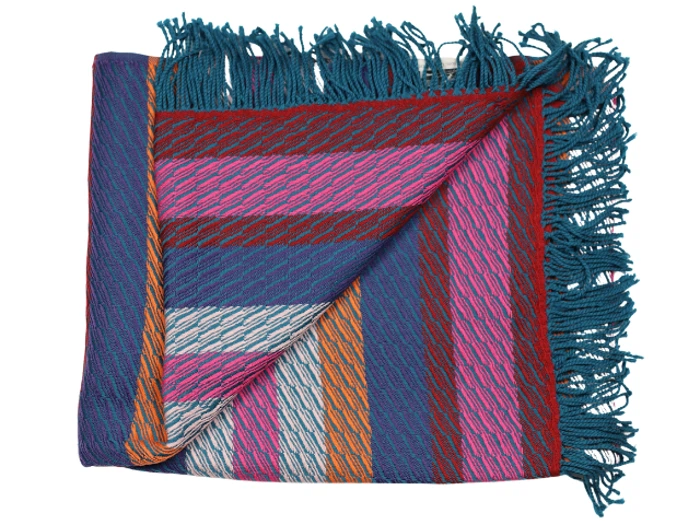 Et foldet vævet tekstil med frynsede kanter og diagonale striber i blå, pink, lilla, orange og hvide toner.