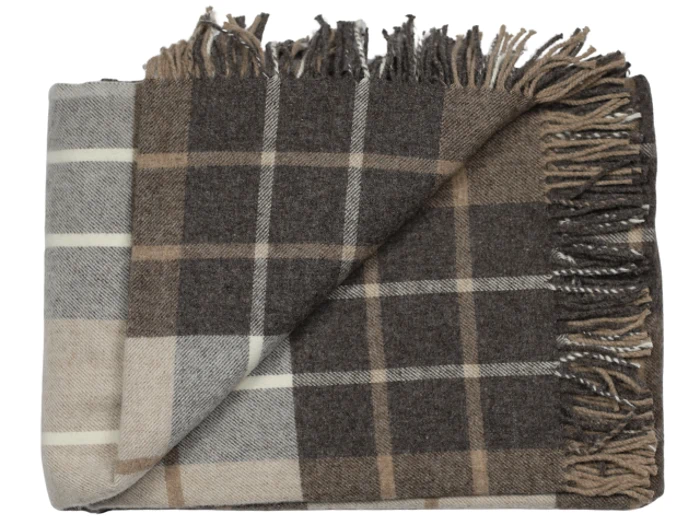Et foldet, frynset plaid-tæppe i brune, beige og cremefarvede nuancer med et ternet mønster.