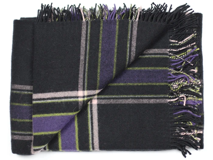 Et foldet uldtørklæde med et sort, lilla, grønt og hvidt ternet mønster og frynsede kanter.