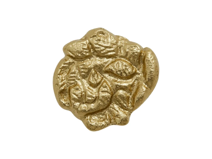Uregelmæssigt formet gammel guldmønt med slidte, prægede mønstre på overfladen, vist på en almindelig hvid baggrund.
