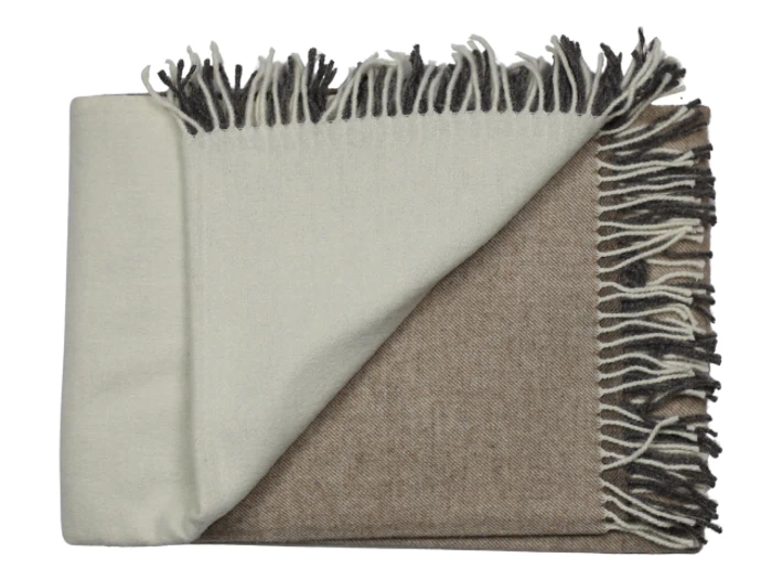 Et foldet uldtæppe med en cremefarvet side og en brun side, med frynsede kanter i blandede cremefarvede og brune nuancer.