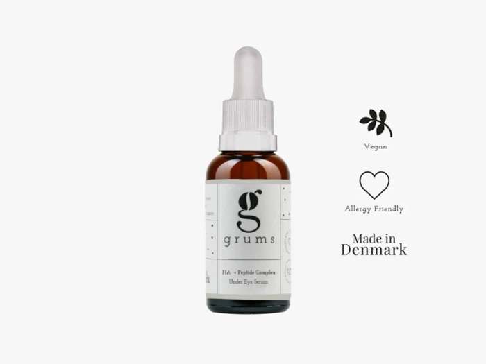 En brun dråbeflaske mærket grums med symboler, der angiver, at den er vegansk, allergivenlig og fremstillet i Danmark, mod en hvid baggrund.