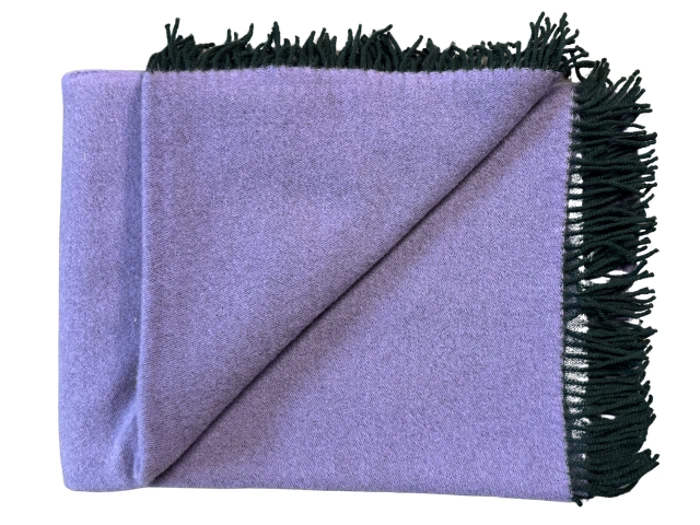 Et foldet lavendeltæppe med sorte frynsekanter, vist på en hvid baggrund.