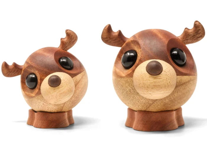 To træfigurer formet som runde hjortehoveder med store sorte øjne, små ører og gevirer, en mindre og en større, placeret side om side på en hvid baggrund.