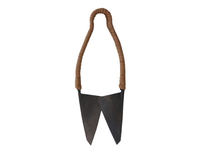 Et nærbillede af en saks med solbrune håndtag omviklet med snor og to store, skarpe knive på en hvid baggrund.