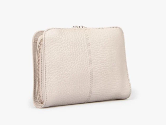 En beige, struktureret læderpung med lynlås, der står oprejst på en almindelig, lys baggrund.