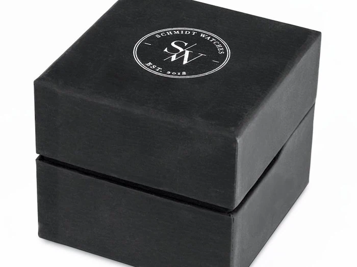 En sort firkantet urkasse med logoet S. Schmidt Watches SW Est. 2018 i hvidt på låget.