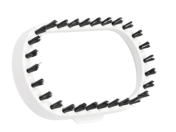 Et hvidt, ovalt børstehoved af plast med korte, sorte børster rundt om den ydre kant, set på en hvid baggrund.