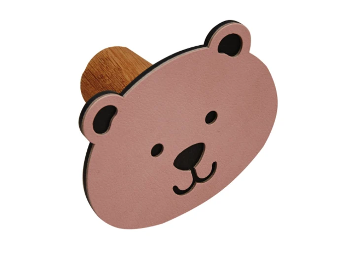 Lyserød bjørneansigtsformet vægknage i træ med enkle sorte detaljer til øjne, næse og mund og en træpind på bagsiden.