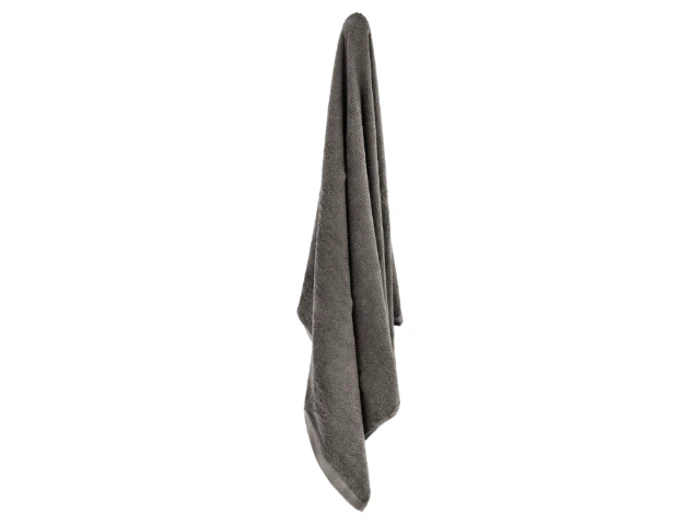 Et gråt håndklæde hænger lodret mod en hvid baggrund.