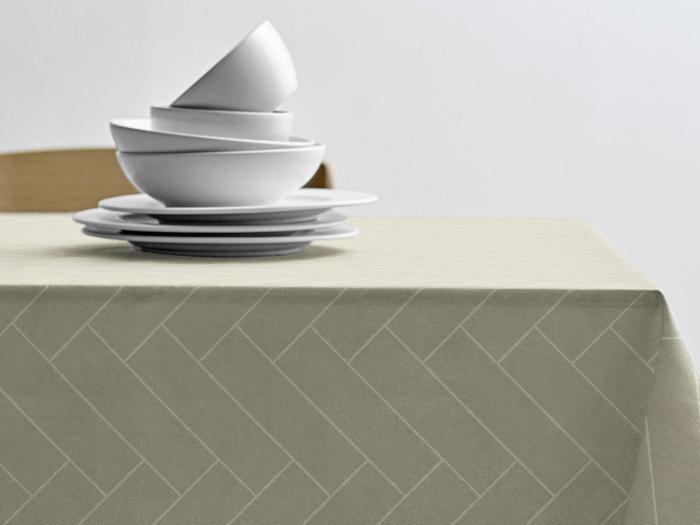 En stak hvide skåle og tallerkener står på en beige dug med et diskret sildebensmønster mod en almindelig hvid baggrund.