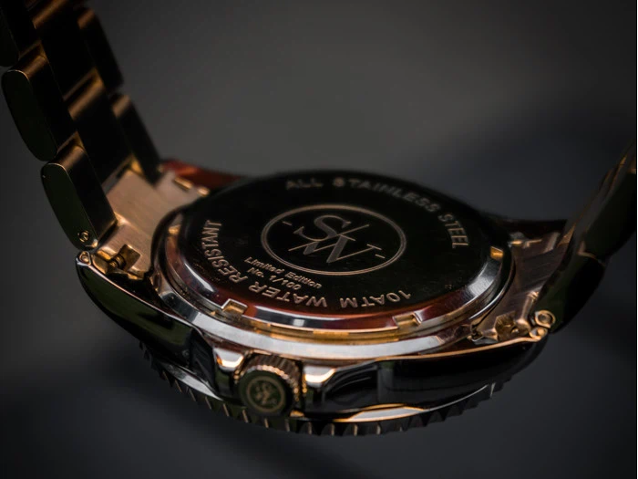 Nærbillede af bagsiden af et armbåndsur i rustfrit stål med indgraveret tekst, der angiver vandtæthed og detaljer om begrænset oplag.