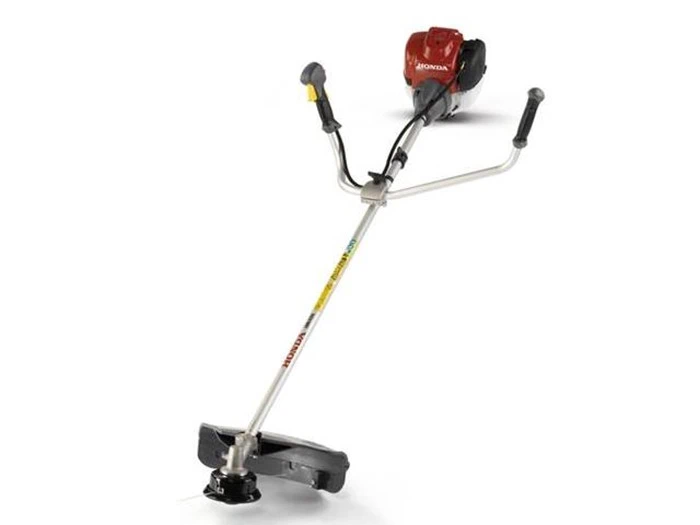 En rød og sølvfarvet gasdrevet buskrydder med et greb i stil med et cykelhåndtag og en beskyttelsesskærm ved det roterende skærehoved.