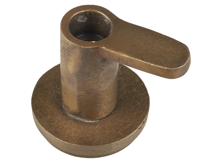 Knastgreb i bronze med en rund base og et fladt, let struktureret håndtag, der strækker sig vandret fra toppen.