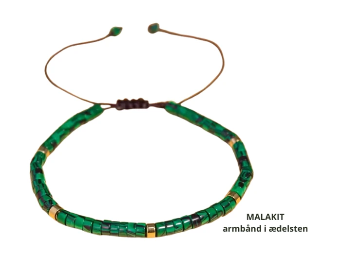 Et grønt malakit-stenarmbånd med gulddetaljer og en justerbar brun snor. Teksten på dansk lyder: MALAKIT armbånd i ædelsten.