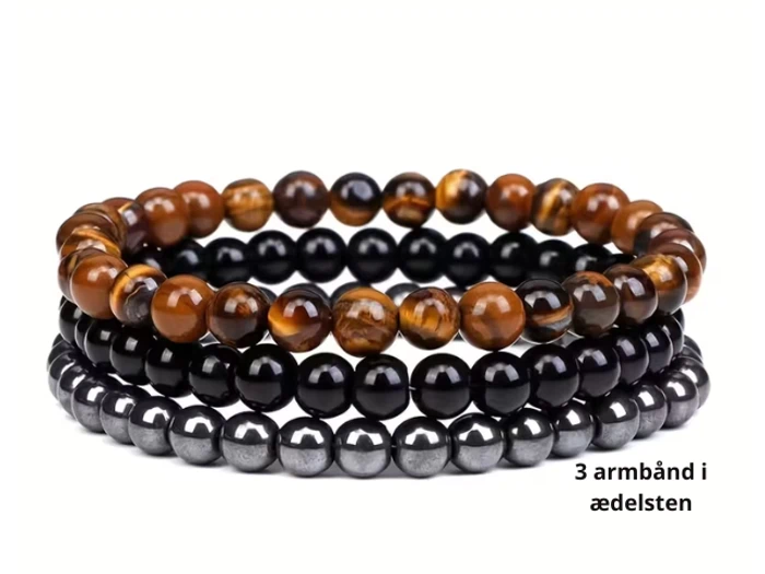 Tre perlearmbånd med ædelsten i brune, sorte og grå toner stablet sammen. Teksten på dansk lyder "3 armbånd i ædelsten.".