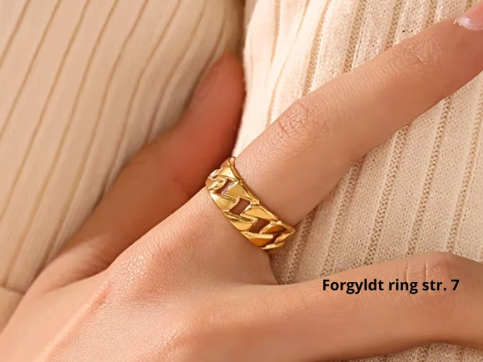 En hånd med en stor guldkædeledsring på pegefingeren med teksten Forgyldt ring str. 7 ved siden af.