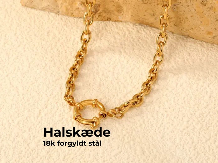 En guldkæde med en rund lås vises på en struktureret beige overflade. Teksten lyder: Halskæde, 18K forgyldt stål.