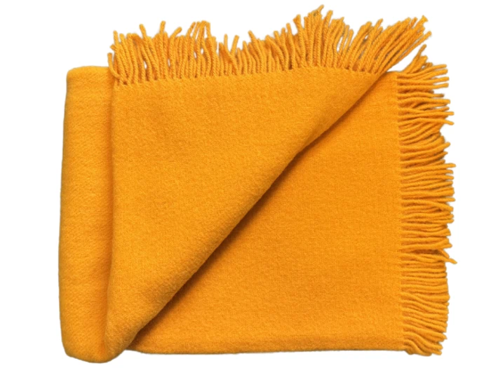Et foldet, levende gult tæppe med frynsede kanter, pænt arrangeret på en hvid baggrund.